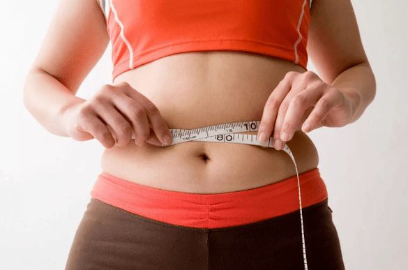 La fille mesure le volume de la taille